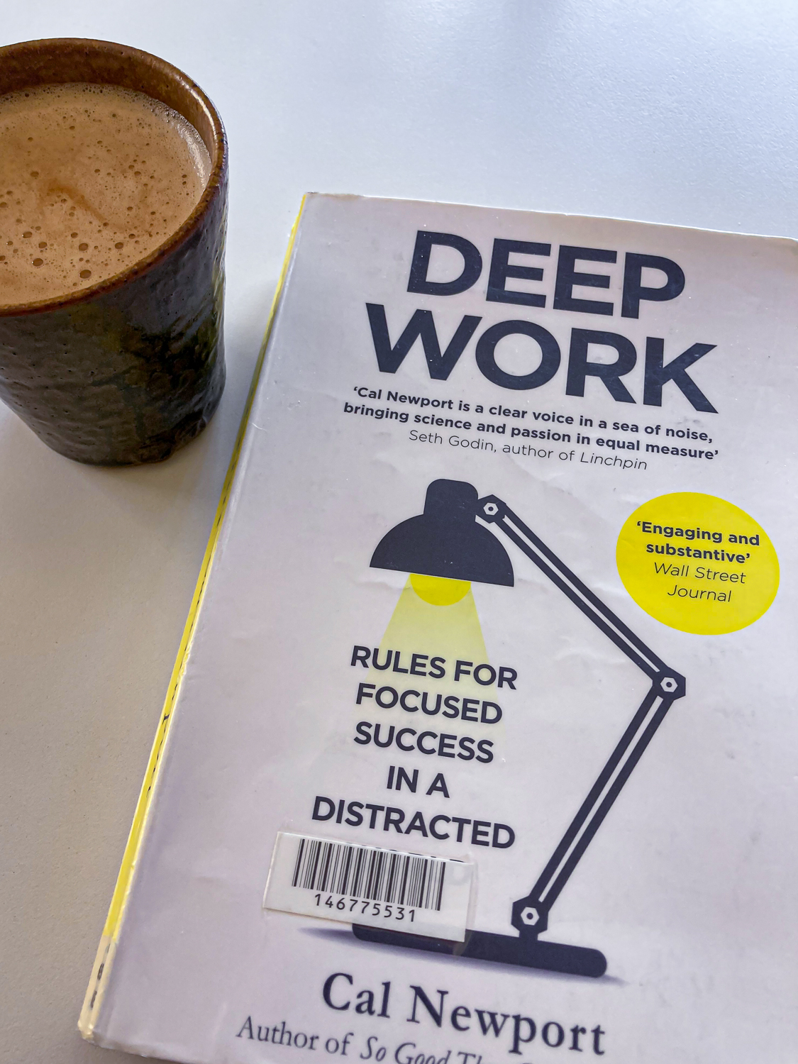 The book Deep Work by Cal Newport next to a cup of coffee
