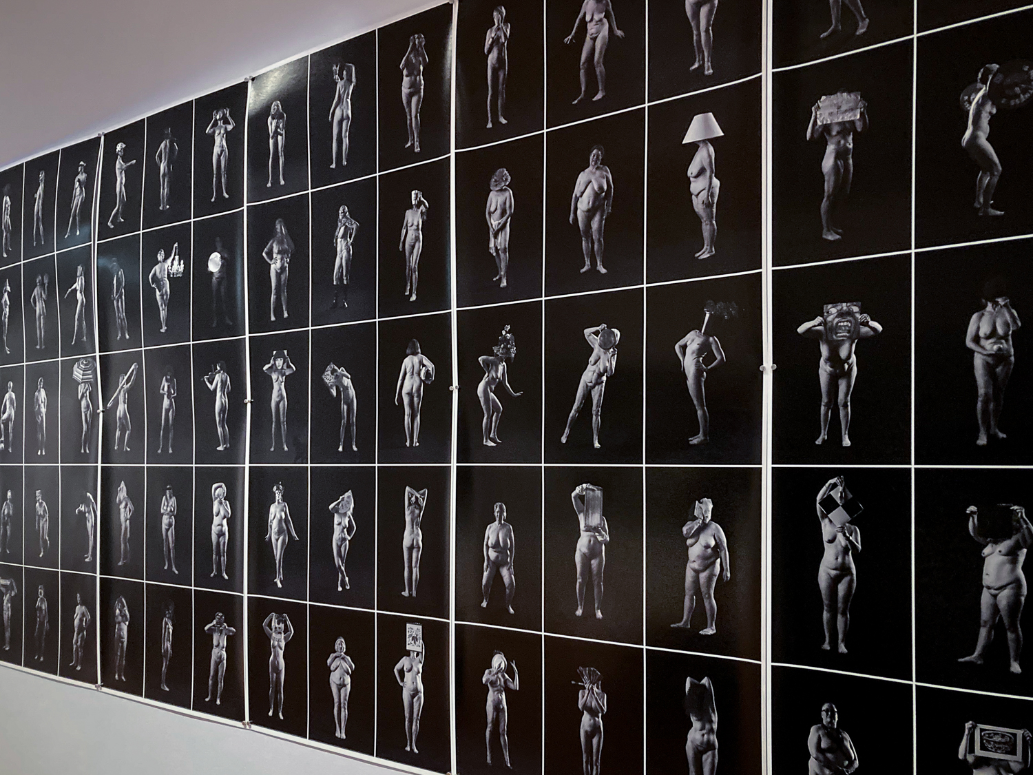 A series of black and white images of naked women on a gallery wall